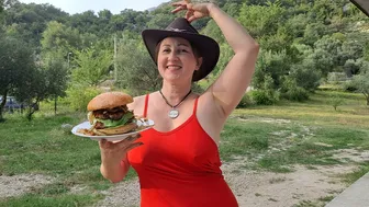 Big burger on fire. Cooking in a mountain village. Mila cooking on an open fire. Mila naturist.