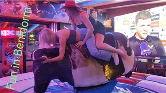 Beautiful ladies riding mechanical bull in Benidorm